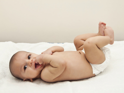 Smiling baby in nappy lying on back