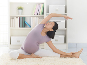 pregnant woman doing yoga on the floor