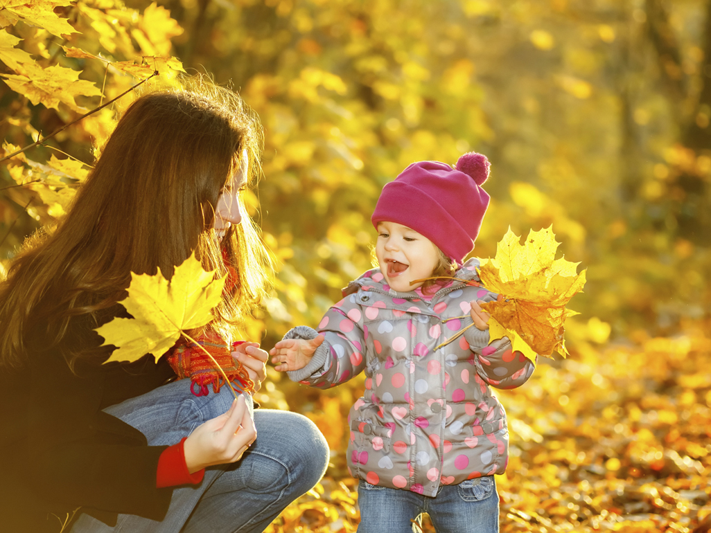 Girl in dress holding up leaf