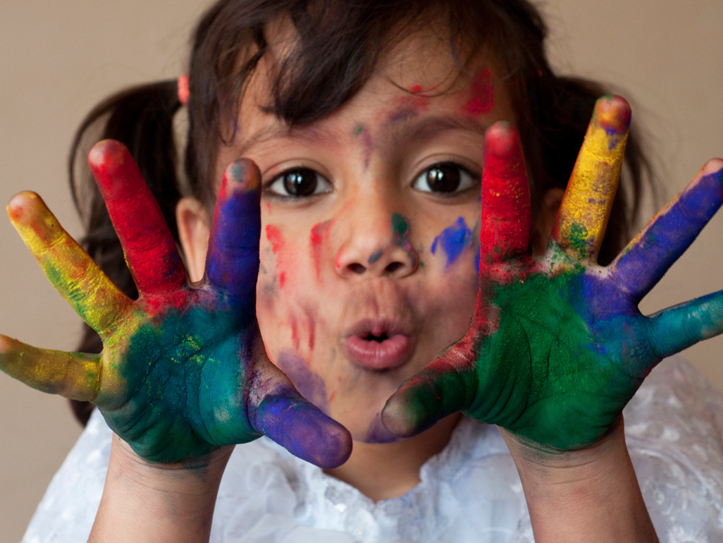 Girl with hands covered in paint