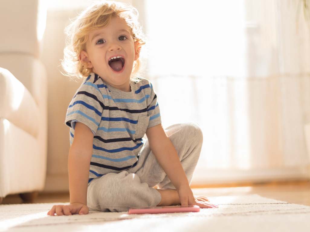 boy sitting on the ground with mouth wide open