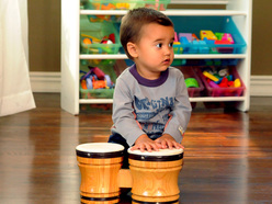 Kleiner Junge spielt auf Bongos