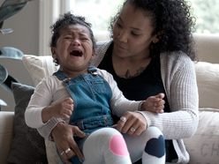 A mother comforting a toddler having a tantrum