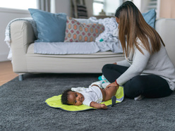 Woman changing baby's diaper