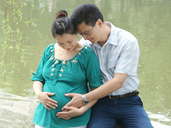 Pregnant woman holding up her phone to show the BabyCenter app