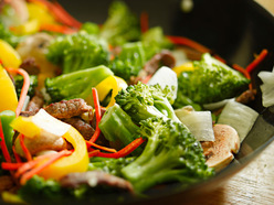 wok full of stir-fried beef, broccoli, capsicum and mushrooms