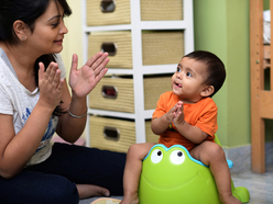 Mum helping little boy on potty