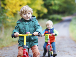 Two toddler boys riding balance bikes