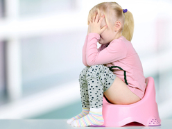 toddler sitting on a potty with her head in her hands