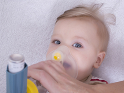 young child being treated for asthma with an inhaler