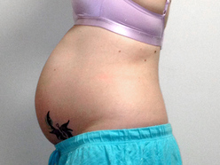 woman 25 weeks pregnant showing her belly