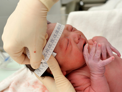 newborn having head measured at hospital