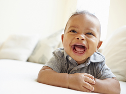 baby laying on tummy with head up smiling