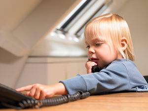 girl sitting at the desk and using phone to dial