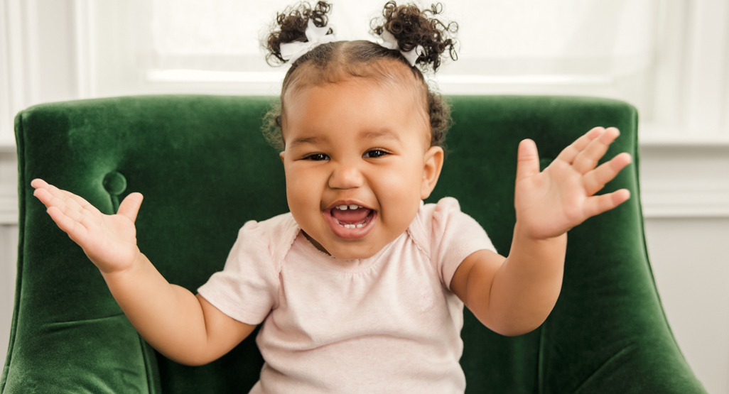 A baby smiling and clapping