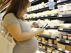 Mujer comprando queso en supermercado