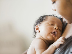 bebê negro dormindo no colo da mãe