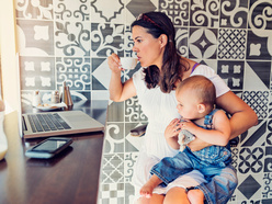 mulher tomando café com filho no colo