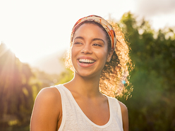 mulher negra sorrindo ao ar livre 