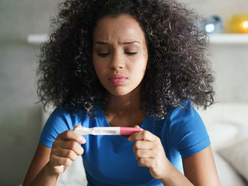 Woman in bathroom looking at pregnancy test result