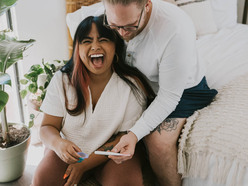 Homem branco e mulher negra comemoram teste positivo de gravidez 