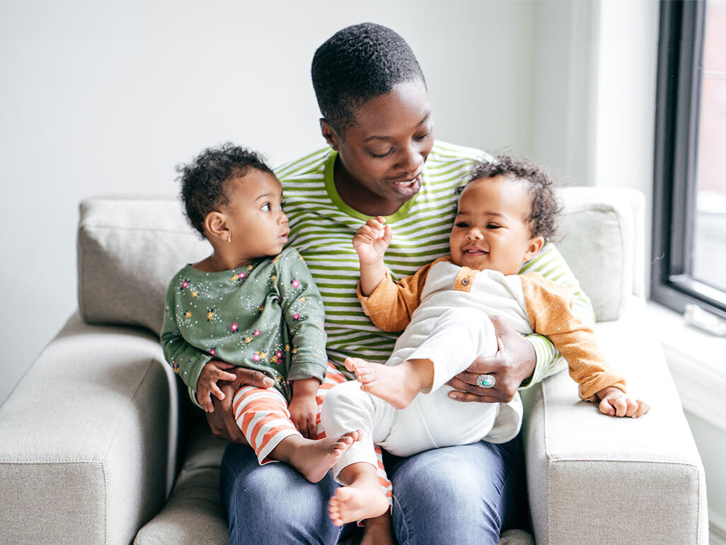 A mom holding two twin girls