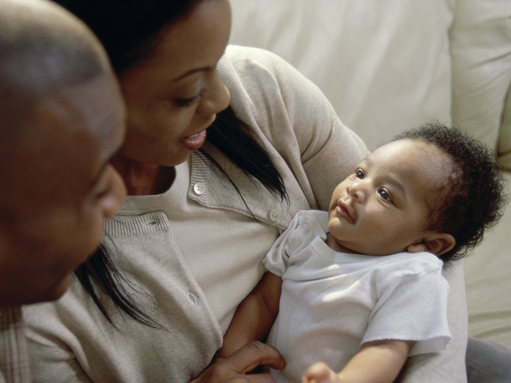 African-American mom and dad holding their baby