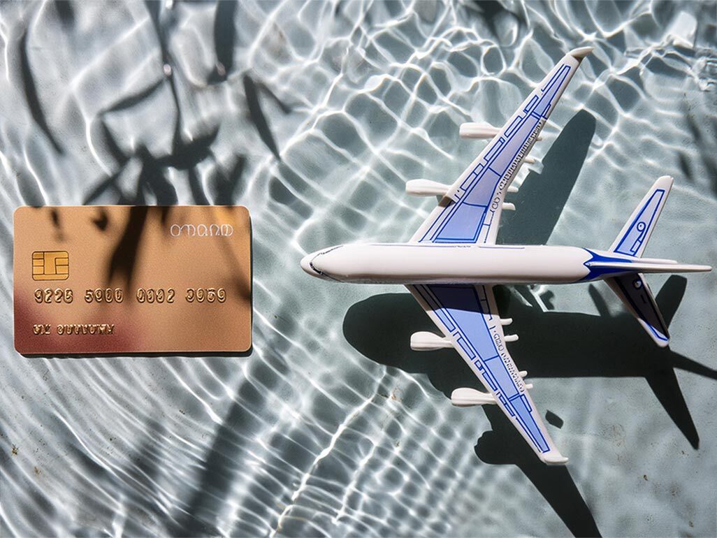 toy plane and credit card on a watery blue background