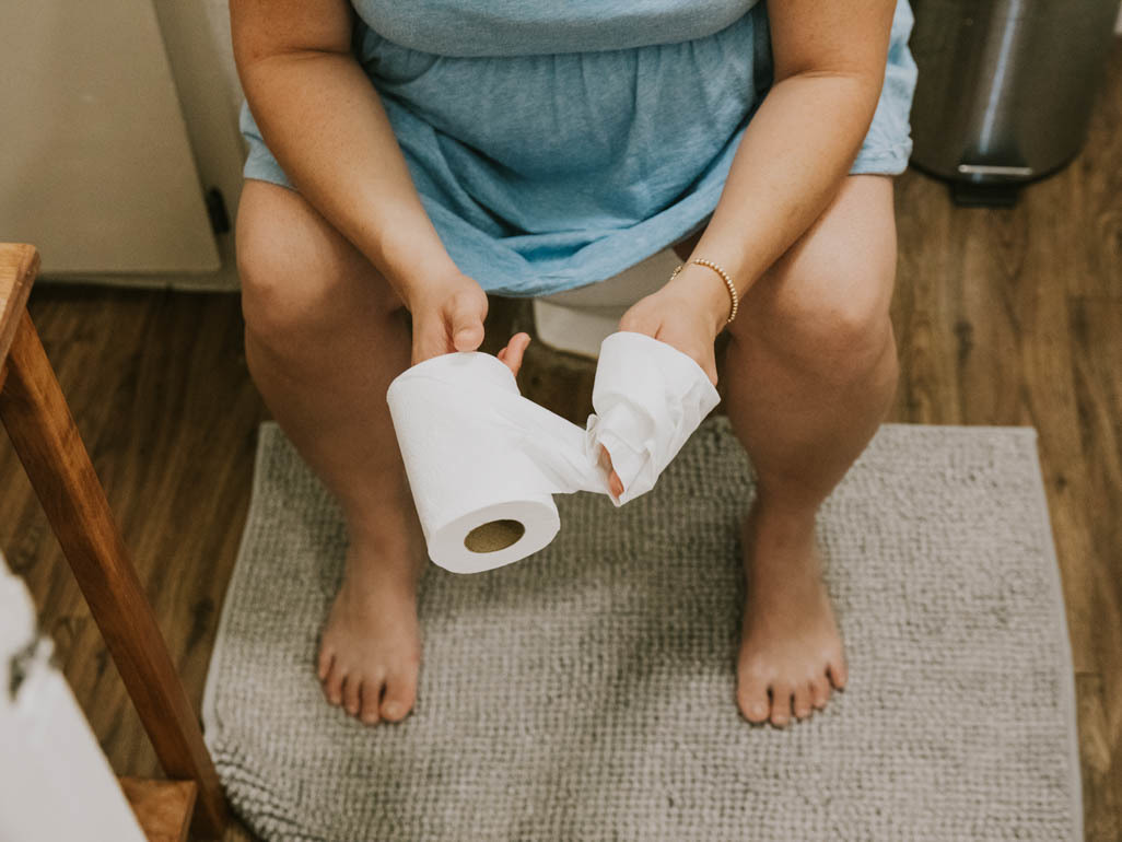 pregnant woman sitting on toilet