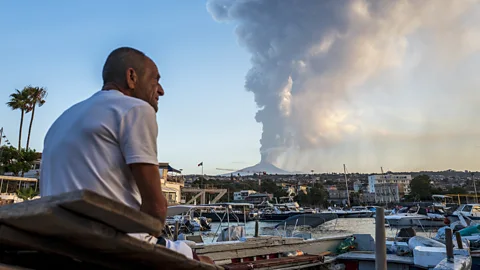 A fisherman observing the eruption of Mount Etna on 4 August 2024 (Credit: Getty Images)