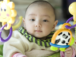 A baby playing with rattles