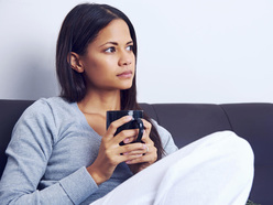 woman holding a cup, looking into the distance