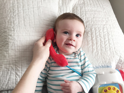 baby talking on toy telephone