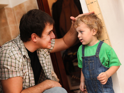 A father measuring the height of a child