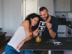 woman and partner looking at ultrasound photos