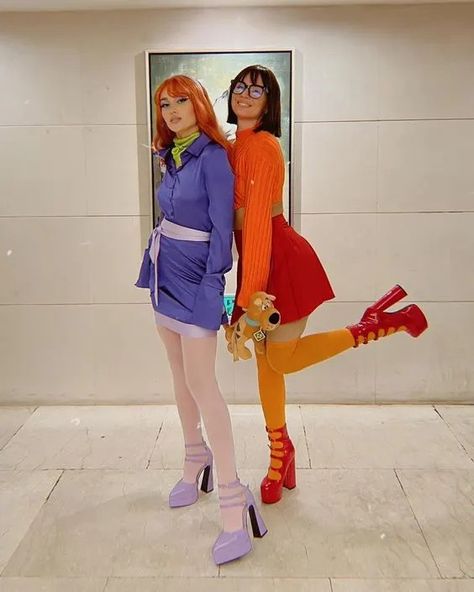 two women dressed in colorful outfits standing next to each other