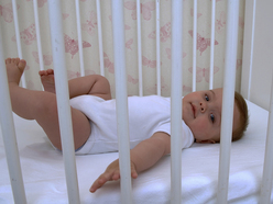 baby laying on it's back in crib while awake