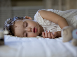 A toddler sleeping in a bed