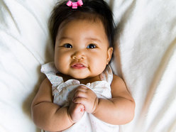 baby girl lying on her back smiling