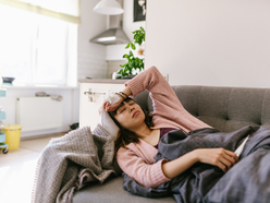 woman lying on the couch feeling ill