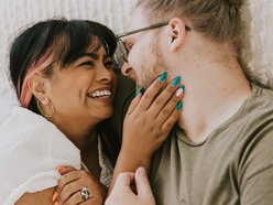 A couple embracing and smiling on a bed