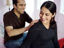 Dad-to-be massaging his pregnant partner's back during labour