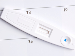 home pregnancy test on top of a calendar