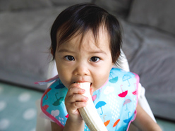 Toddler girl eating a banana