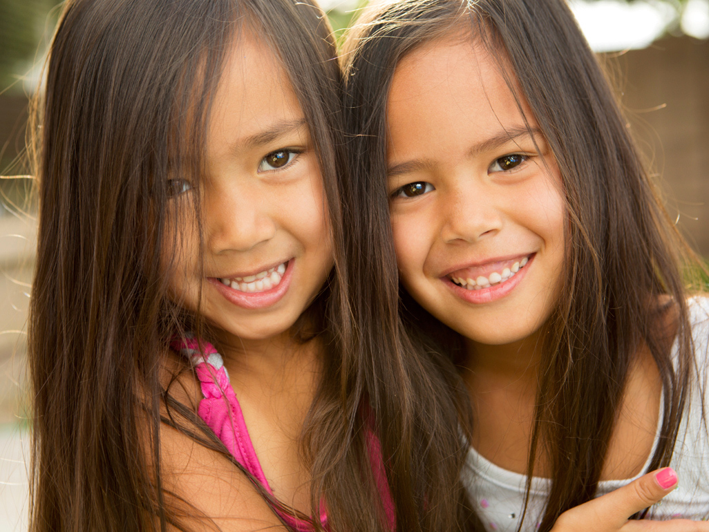 two sisters holding their heads next to each other